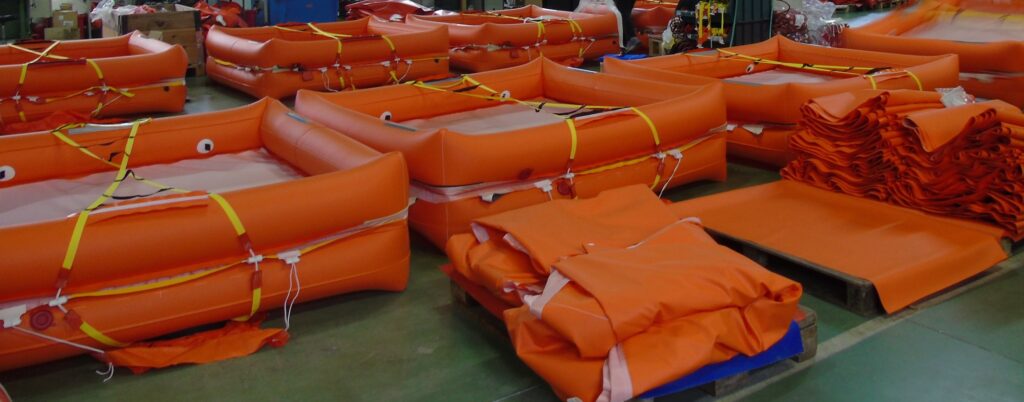 Zattere di salvataggio arancioni pronte per l'uso in un'area di produzione industriale.